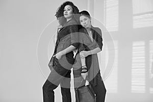 Elegant couple of black and asian women in fashionable green and