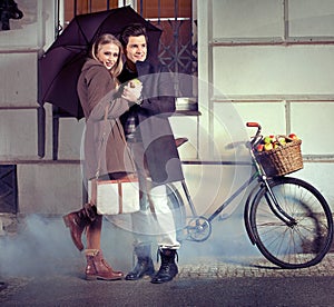 Elegant couple with umbrella on rainy evening