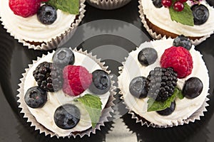 Elegant Cupcakes with Berries on the Black Plate