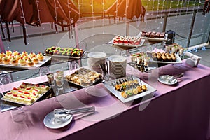 Elegant decorated banquet table. Sweet tasty cupcakes, candies on wedding party. Rows of different desserts