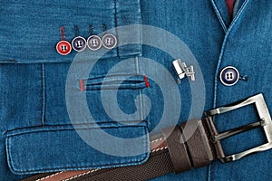 Elegant denim suit with a silver cufflinks and belt. Male jacket with cufflinks and pockets, close-up. Men`s fashion.