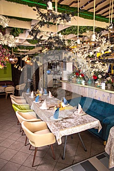 Elegant dining area with greenery, long table with crystal glasses and napkins.