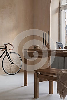 Elegant dining room interior composition with wooden dining table, armchair, bike and design home decorations. home staging.