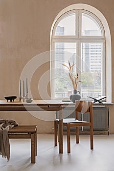 Elegant dining room interior composition with wooden dining table, armchair and design home decorations. Modern home staging.