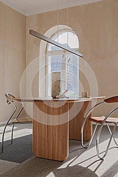 Elegant dining room interior composition with wooden dining table, armchair and design home decorations. Modern home staging.