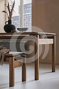 Elegant dining room interior composition with wooden dining table, armchair and design home decorations. Modern home staging.