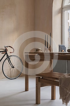 Elegant dining room interior composition with wooden dining table, armchair, bike and design home decorations. home staging. photo