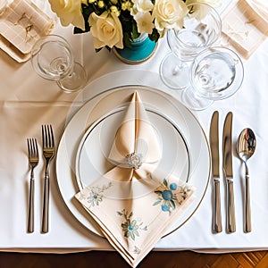 Elegant dinner table setting arrangement in English country style as flatlay tablescape, folded napkin on a serving plate,