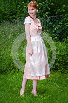 Elegant in a dirndl on the meadow