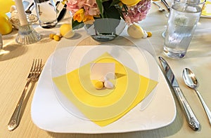 Elegant Easter table setting with flowers, dinner plates, easter