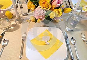 Elegant Easter table setting with flowers, dinner plates, easter