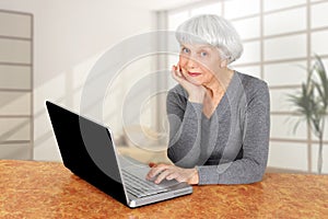 Elegant elderly senior woman using laptop computer communicates photo