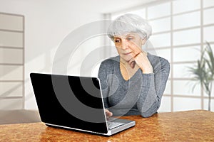 Elegant elderly senior woman using laptop computer communicates photo