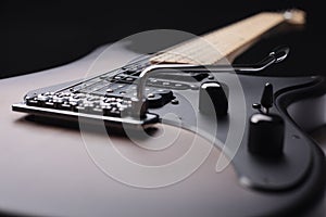 Elegant electric guitar on black background close up point of view showing large part from body