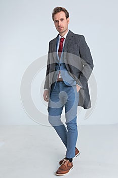 Elegant fashion businessman with suit and coat standing