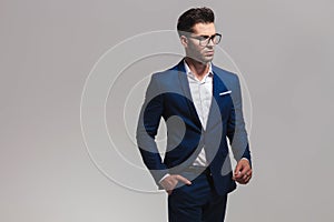 Elegant fashion man in glasses looks away to side