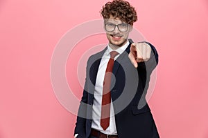 Elegant fashion man in suit wearing glasses and pointing fingers