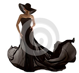 Elegant Fashion Model in Black Dress. Sexy Woman Silhouette in Hat. Luxury Lady in Long Evening Gown with Waving Fabric over White