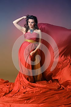 Elegant Fashion Model in Fluttering Red Gown