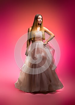 Elegant fashion. Stunning woman in elegant long dress in studio. Luxury evening fashion. Glamour fashion model. Elegance