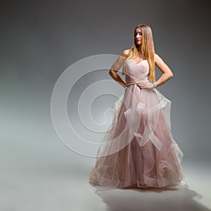 Elegant fashion. Stunning woman in elegant long dress in studio. Luxury evening fashion. Glamour fashion model. Elegance