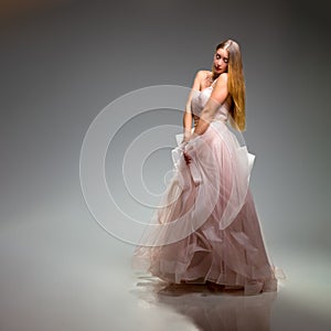 Elegant fashion. Stunning woman in elegant long dress in studio. Luxury evening fashion. Glamour fashion model. Elegance