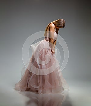 Elegant fashion. Stunning woman in elegant long dress in studio. Luxury evening fashion. Glamour fashion model. Elegance