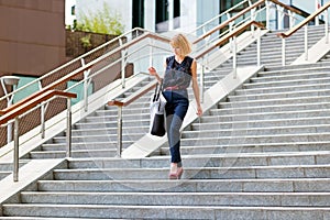 Elegant fashionable woman descending exterior steps in town