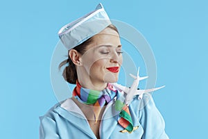 elegant female air hostess on blue in blue uniform