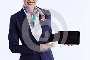 Elegant female air hostess on showing tablet PC blank screen