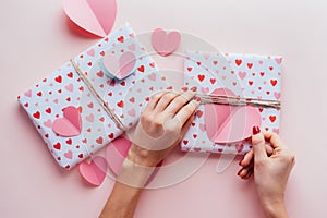 Elegant female hands decorate with heart gift boxes for valentine`s day