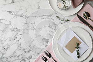 Elegant festive table setting with blank card on marble background, flat lay. Space for text