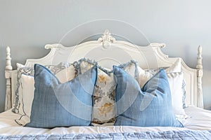Elegant French country bedroom interior with blue decorative pillows on bed