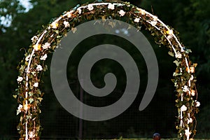 Elegant fresh floral wedding aisle archway with leaves flowers a