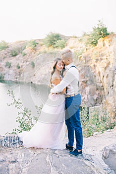 Elegant gentle stylish groom and bride near river or lake
