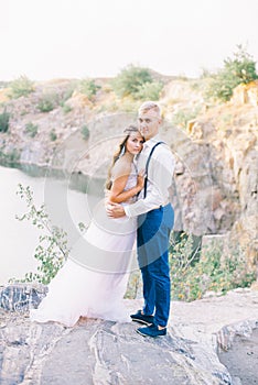 Elegant gentle stylish groom and bride near river or lake