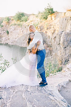 Elegant gentle stylish groom and bride near river or lake