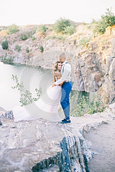 Elegant gentle stylish groom and bride near river or lake