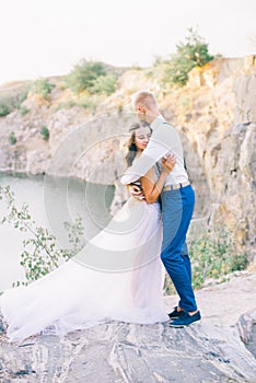 Elegant gentle stylish groom and bride near river or lake