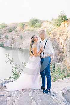 Elegant gentle stylish groom and bride near river or lake