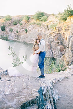 Elegant gentle stylish groom and bride near river or lake