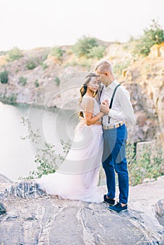 Elegant gentle stylish groom and bride near river or lake