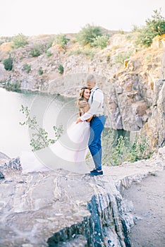 Elegant gentle stylish groom and bride near river or lake