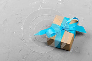 Elegant gift box with blue bow on gray background