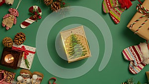 Elegant gift box with shiny golden stars on christmas tree drawing on green 4K