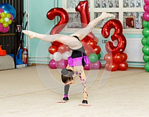 Elegant girl doing crafty splits on art gymnastics competitions