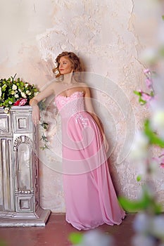 Elegant girl in a pink long evening dress