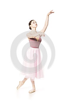 Elegant girl in a pink skirt and beige top dancing ballet