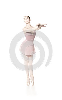 Elegant girl in a pink skirt and beige top dancing ballet