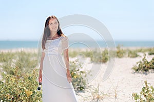 Fashion Woman with Sunglasses Wearing  Long White Dress to the Beach